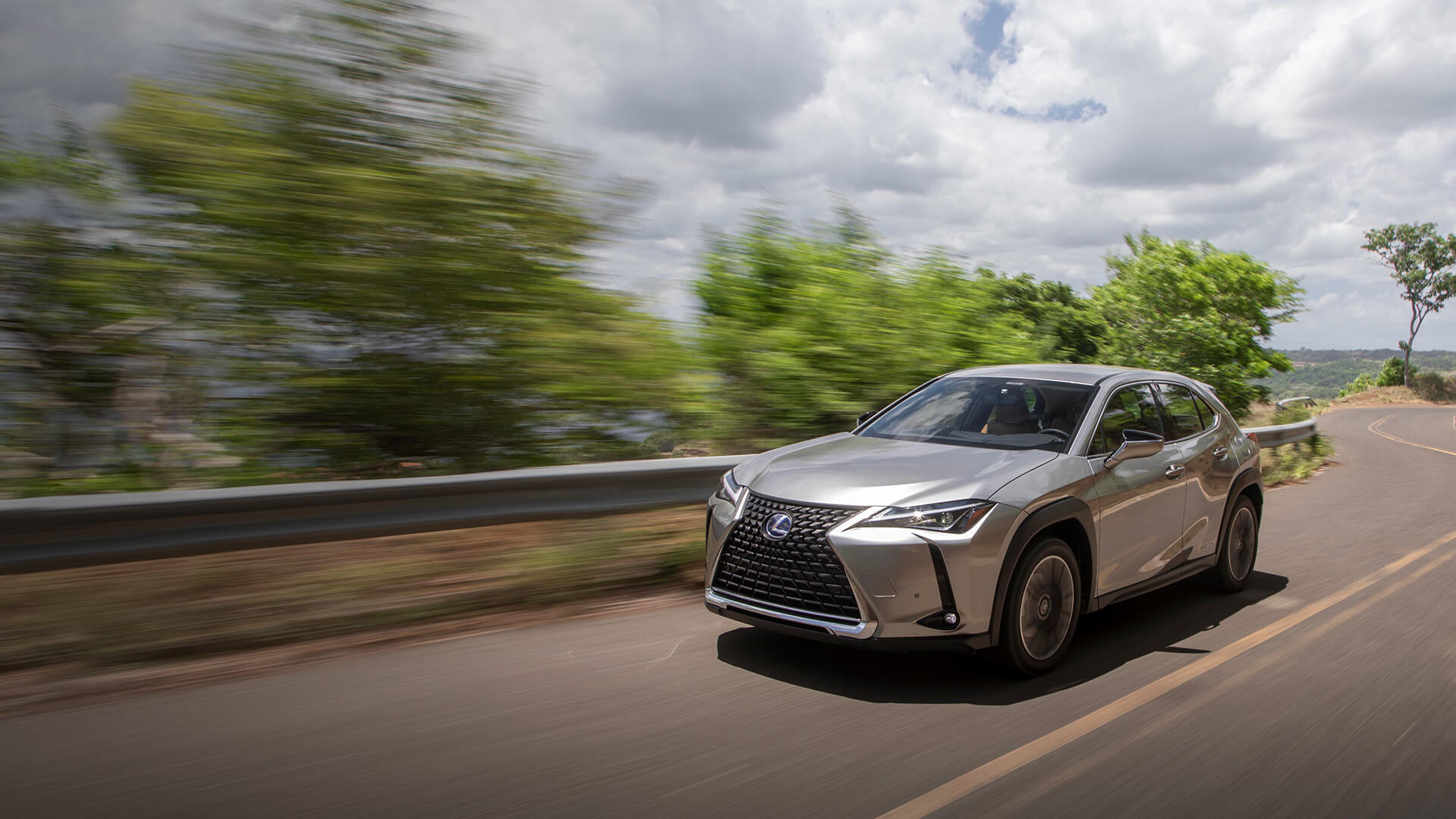 Silver Lexus UX being driven on the road.  